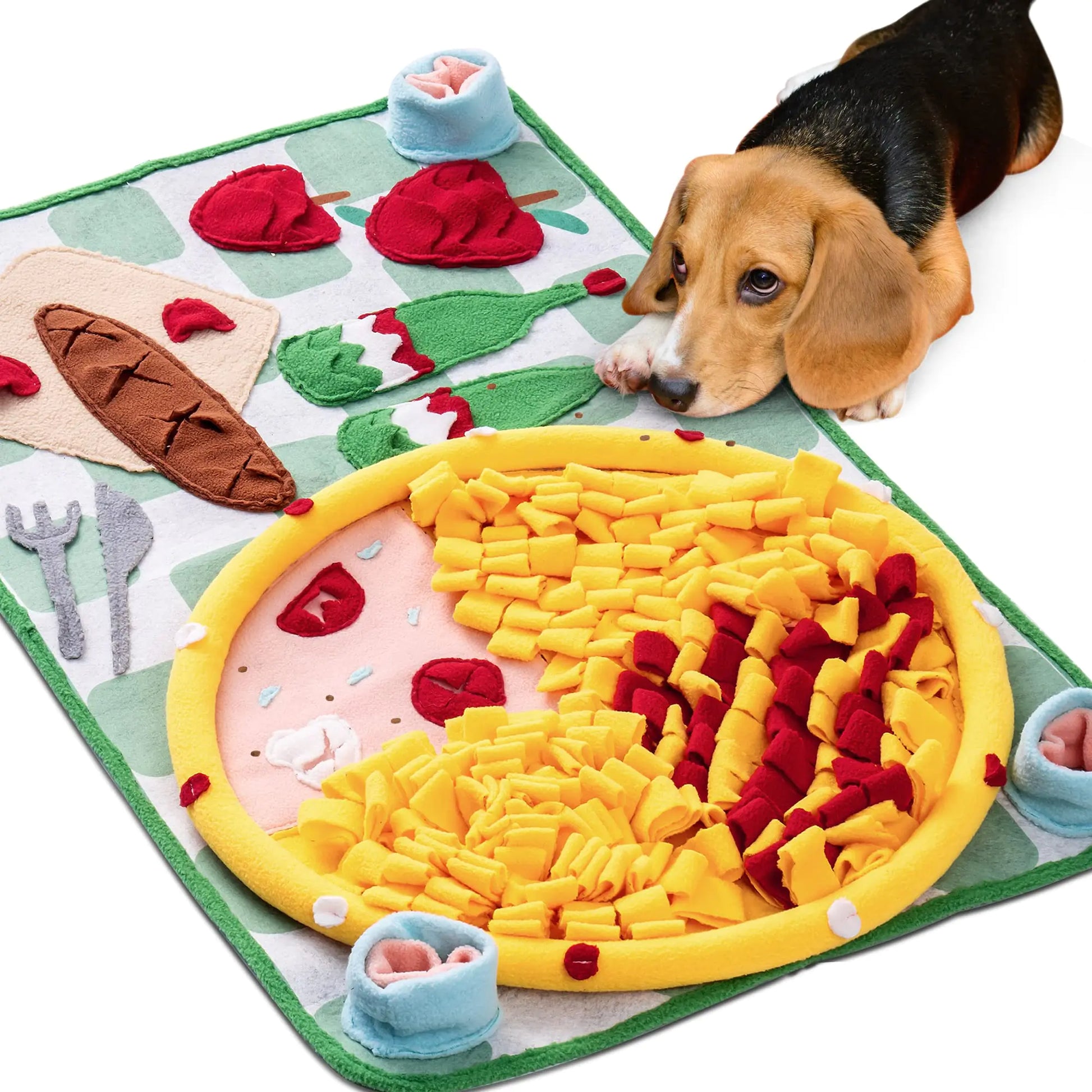 Dog playing with a toy pizza on a mat resembling a dining table setting.