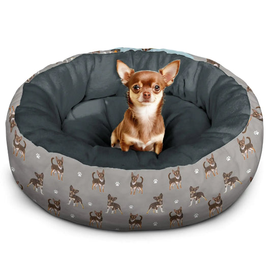 Dog sitting on a gray pet bed with chihuahua pattern