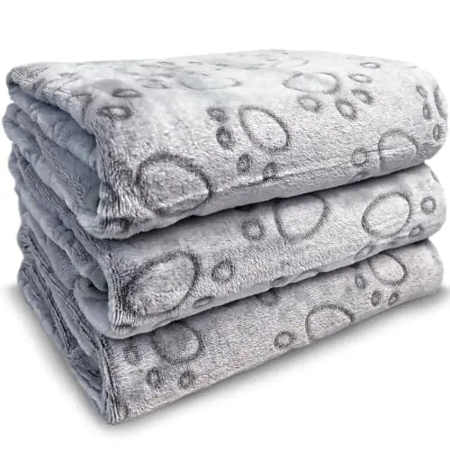 Stack of three folded gray blankets with a pattern on a white background